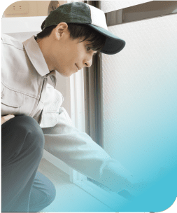 窓の溝をスポンジで掃除する男性